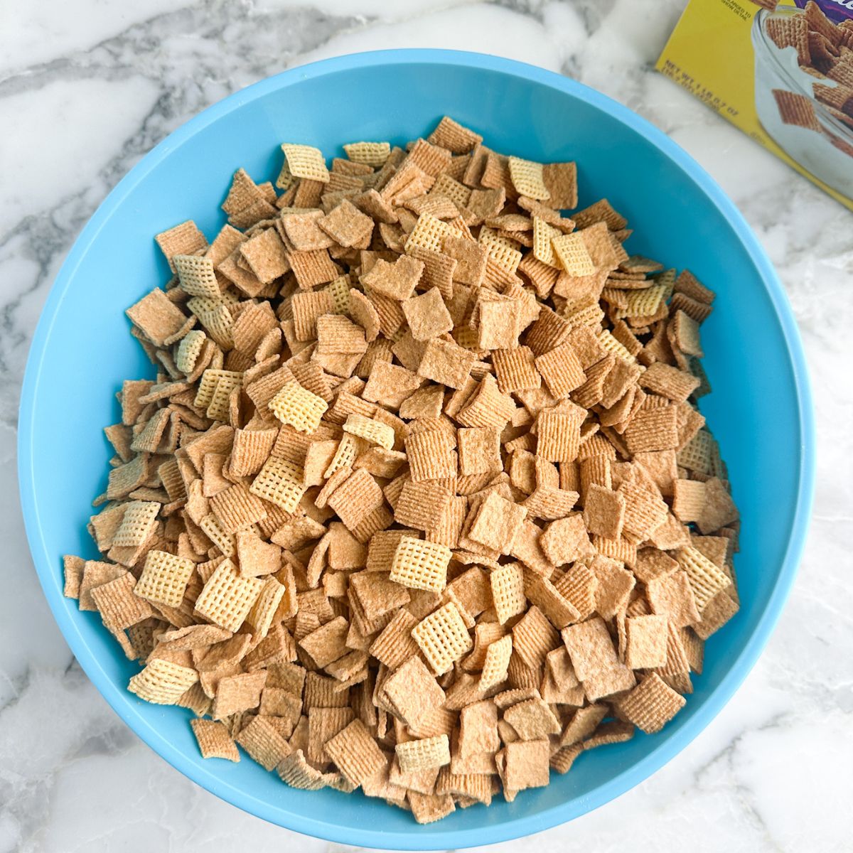 Blue bowl with Chex and Golden Grahams. 