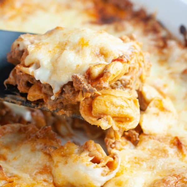 Tortellini casserole with cheese in a baking dish.