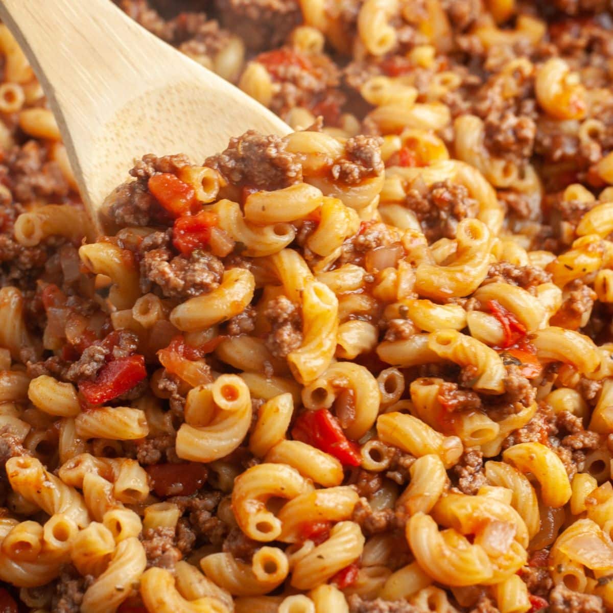 Wooden spoon with beefy elbow macaroni.
