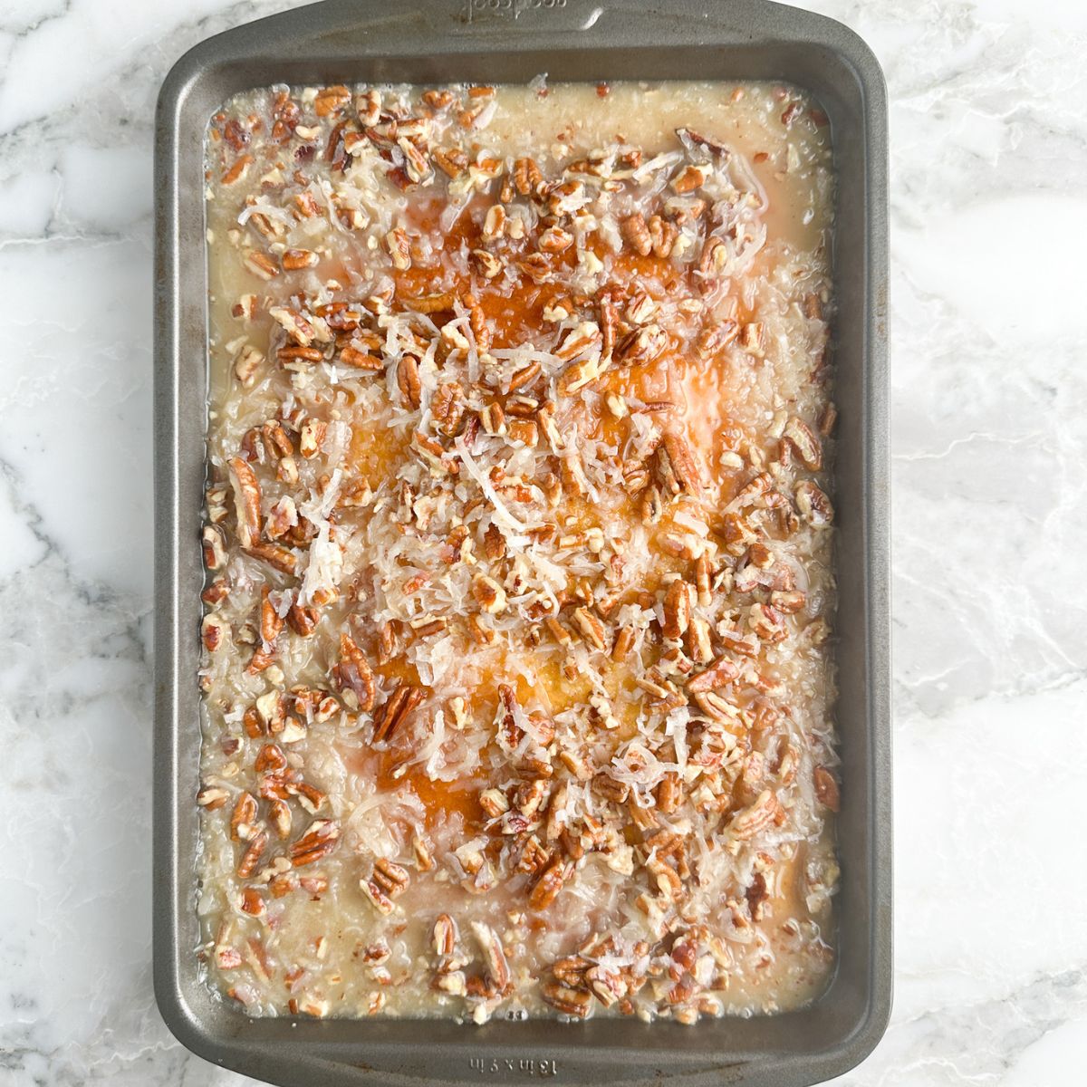 Baking pan with coconut and pecan cake. 
