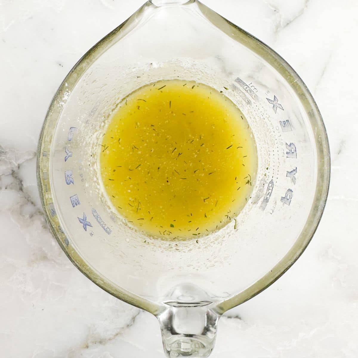 Glass cup with melted butter and seasonings. 