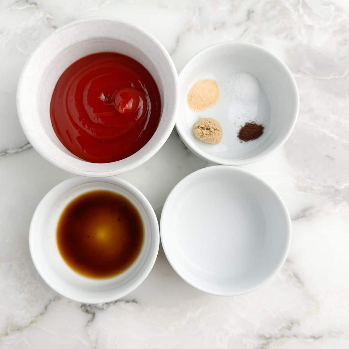 Bowl of ketchup, bowl of vinegar, Worcestershire sauce, and bowl of seasonings.