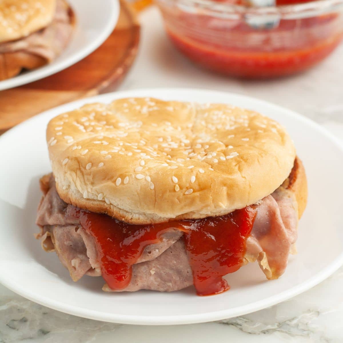 Roast beef sandwich with a red sauce. 