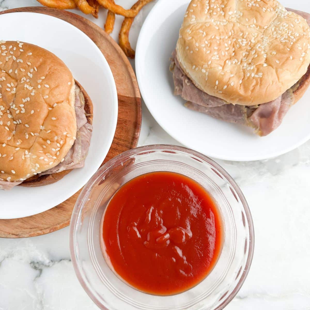 Bowl of red sauce and plate with roast beef sandwiches.