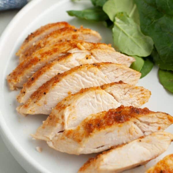 Sliced chicken on a plate with lettuce.