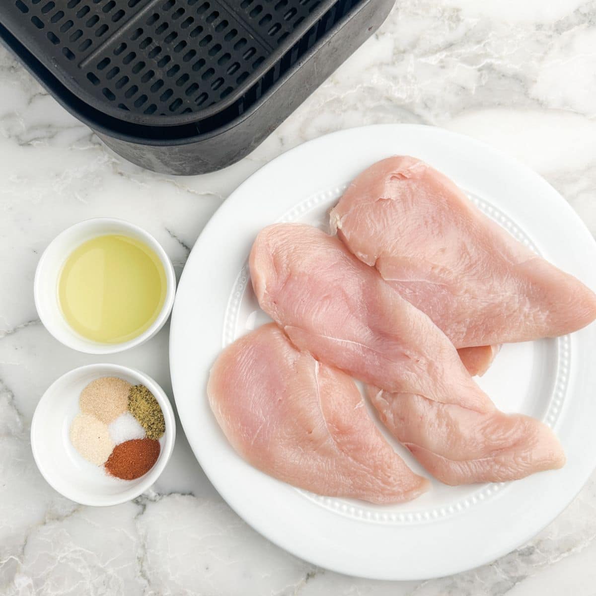 Think chicken breasts on a plate, bowl of seasonings, and olive oil. 
