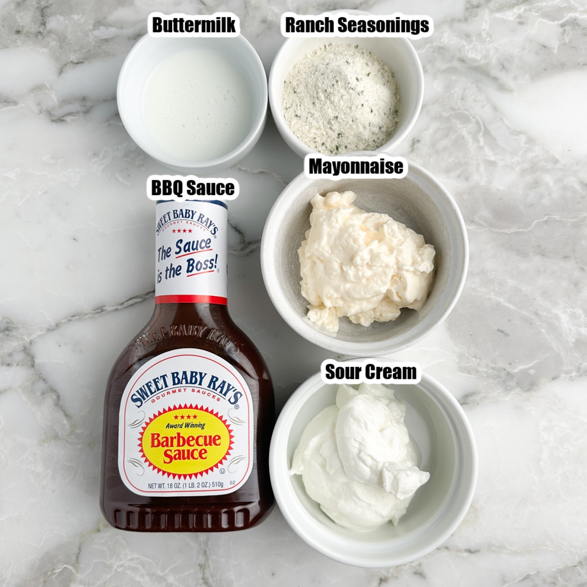 Bottle of BBQ sauce, bowl of sour cream, mayonnaise, seasonings, and buttermilk. 
