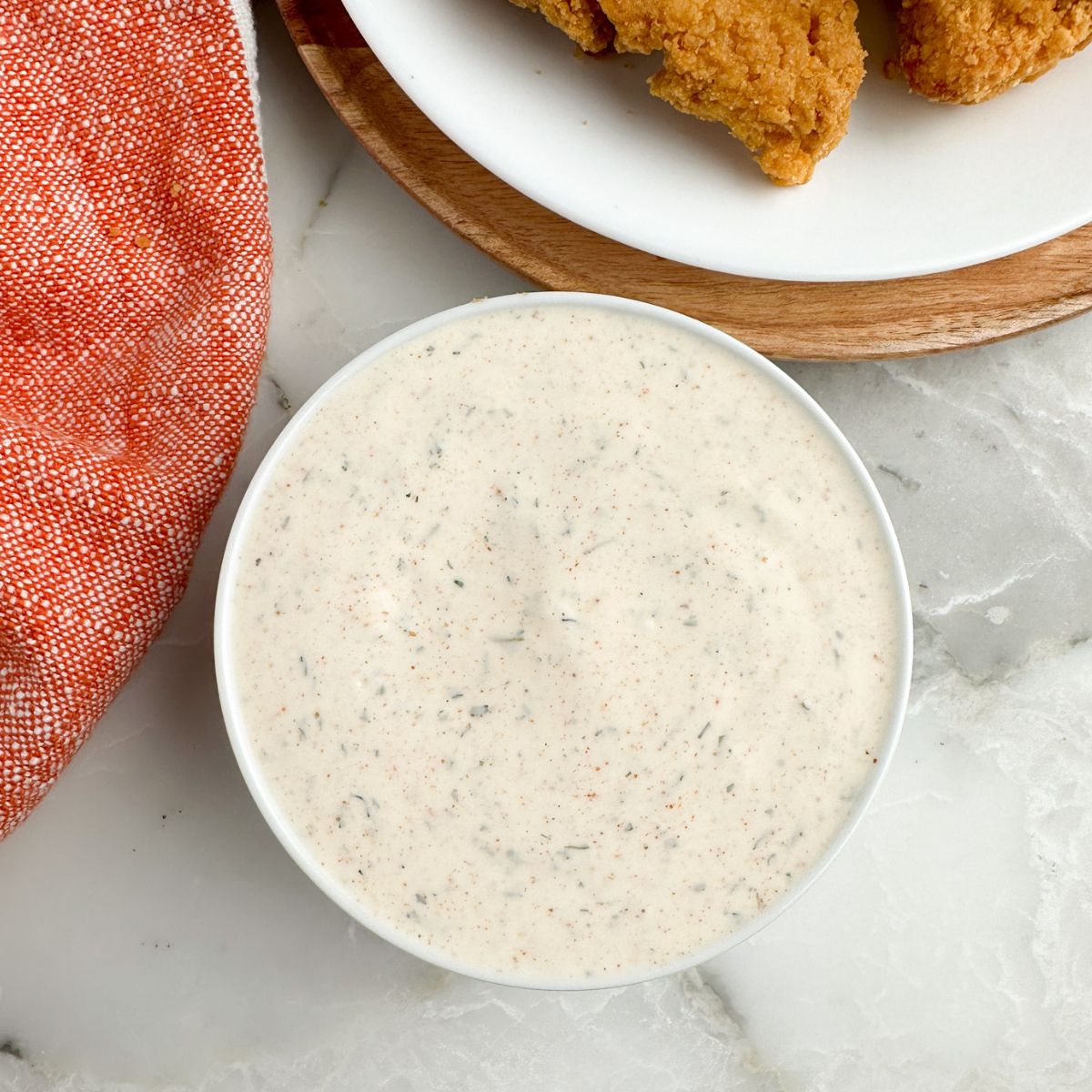 Bowl of sauce and chicken tenders. 