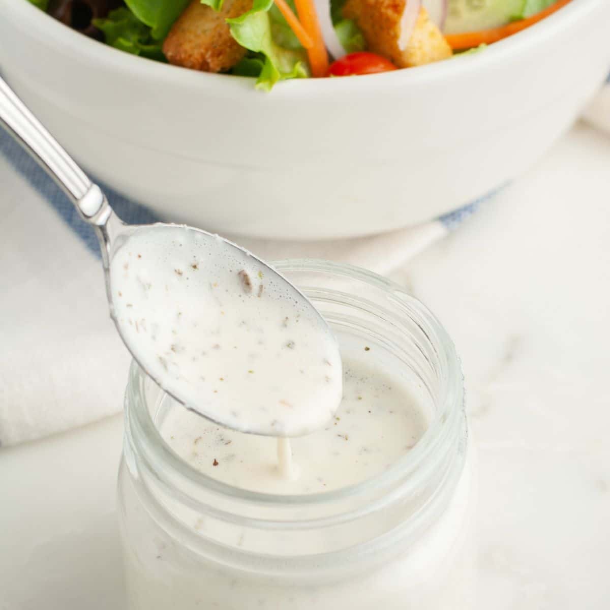 Spoon with salad dressing. 