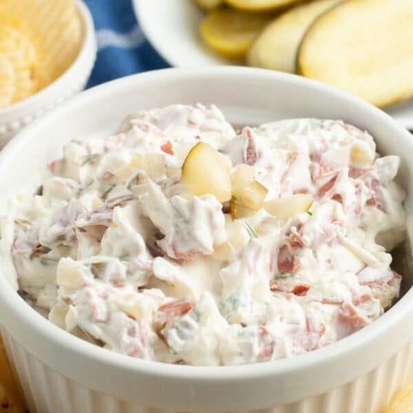 Bowl of creamy dip with dill pickles.