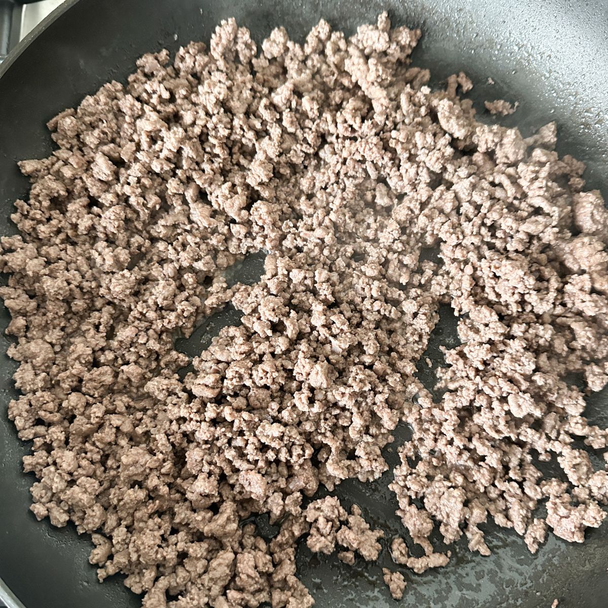 Skillet with cooked ground beef. 