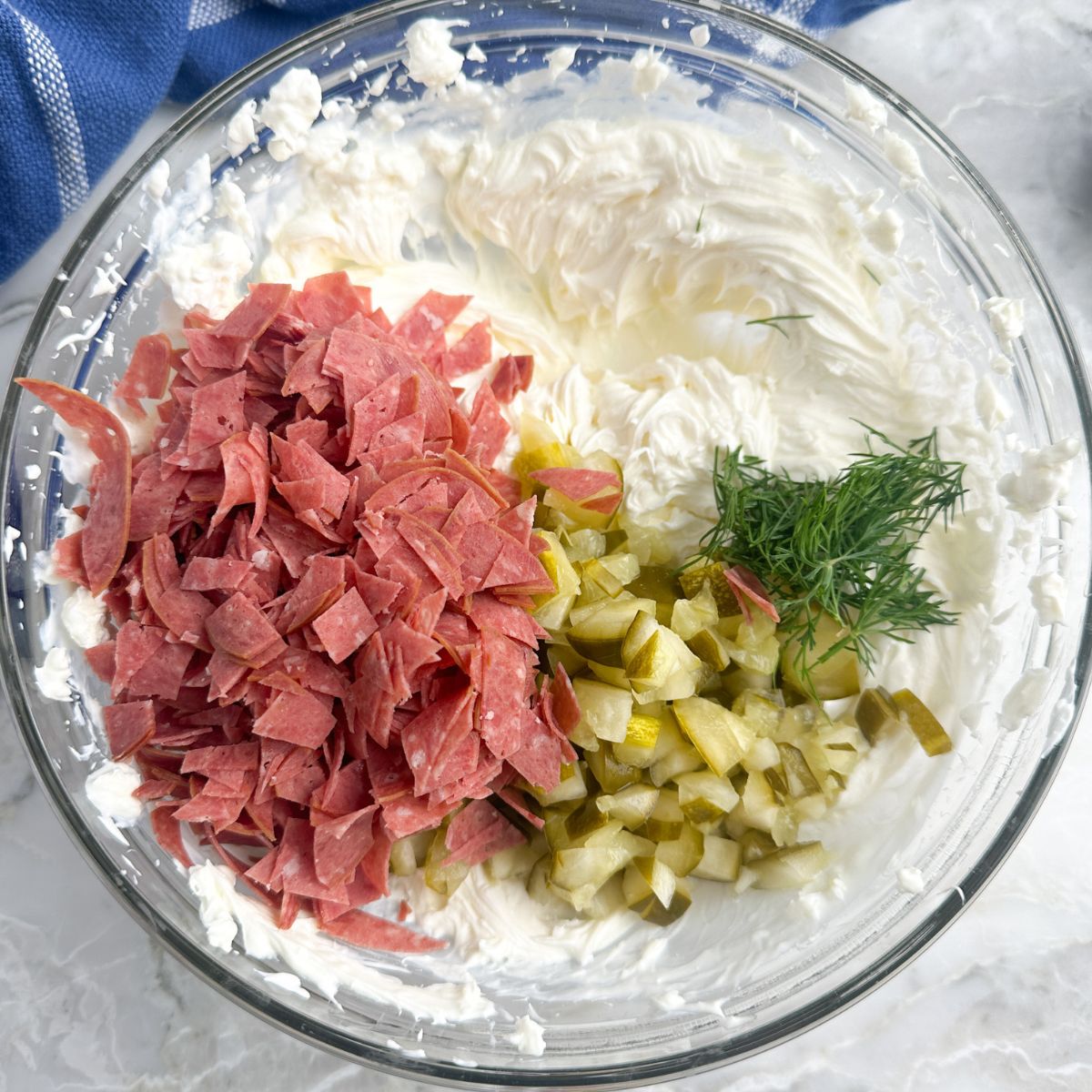 Bowl with cream cheese, dried beer, and chopped dill pickles. 