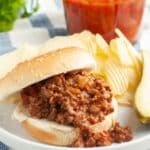 Sloppy joe sandwich on a plate with potato chips.