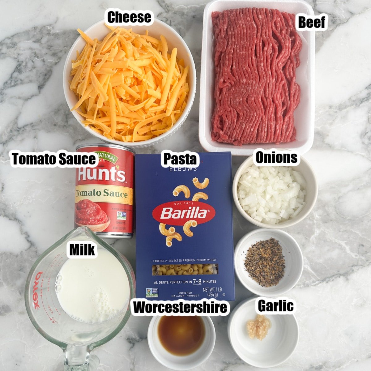 Ground beef, bowl of cheese, pasta, can of tomato sauce, and milk. 