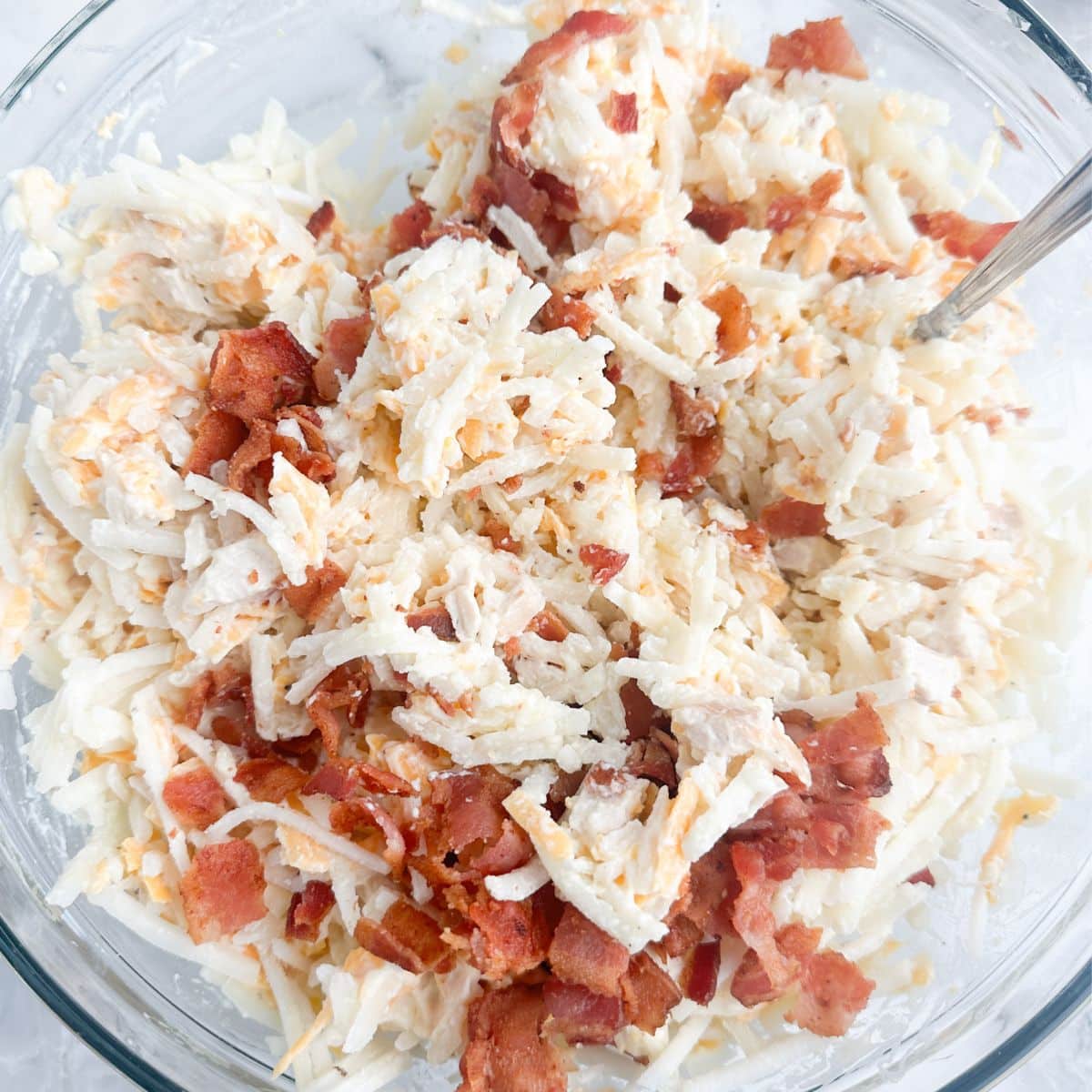 Bowl with hash browns, bacon crumbles, and chicken. 