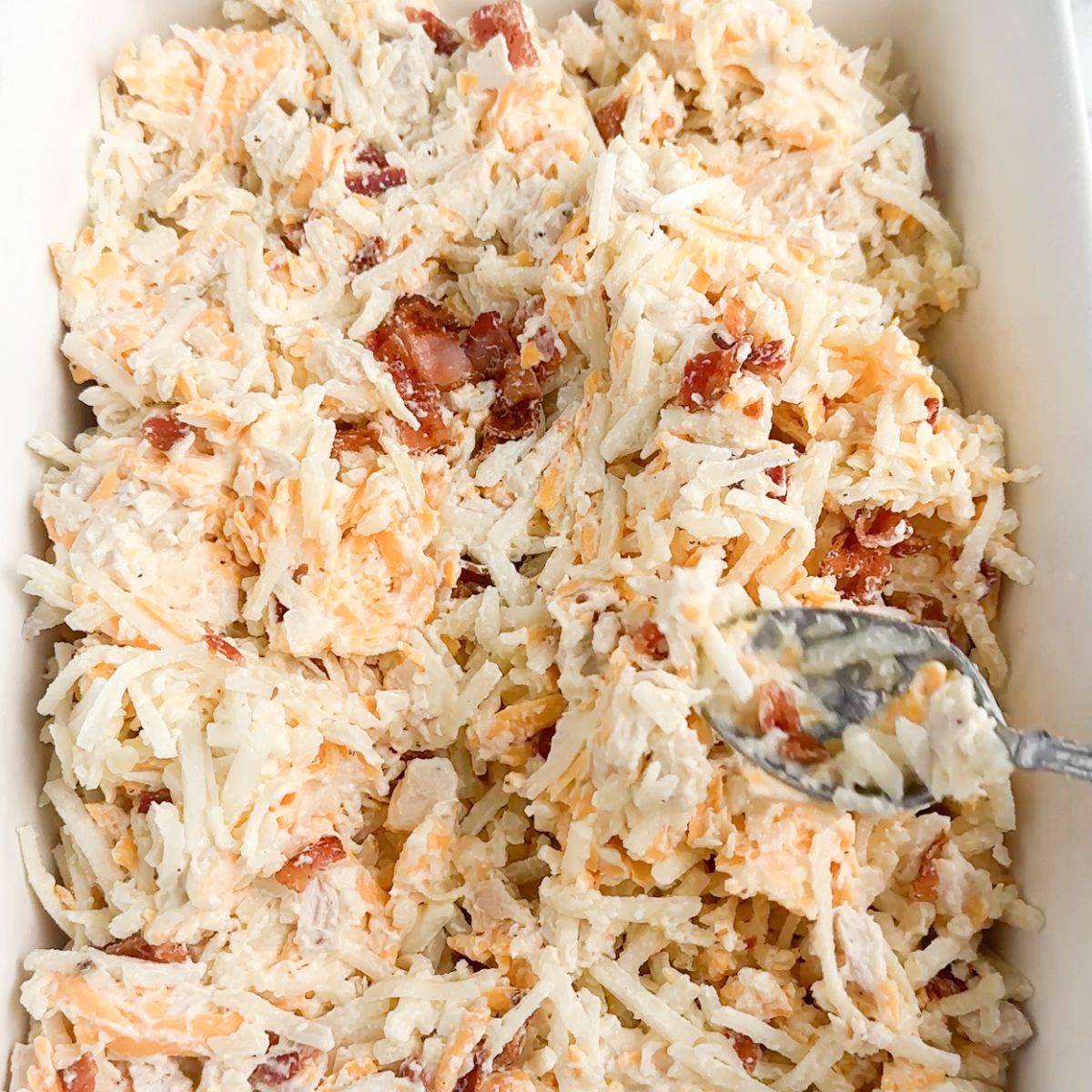 Casserole dish with chicken, bacon, and hash brown mixture. 