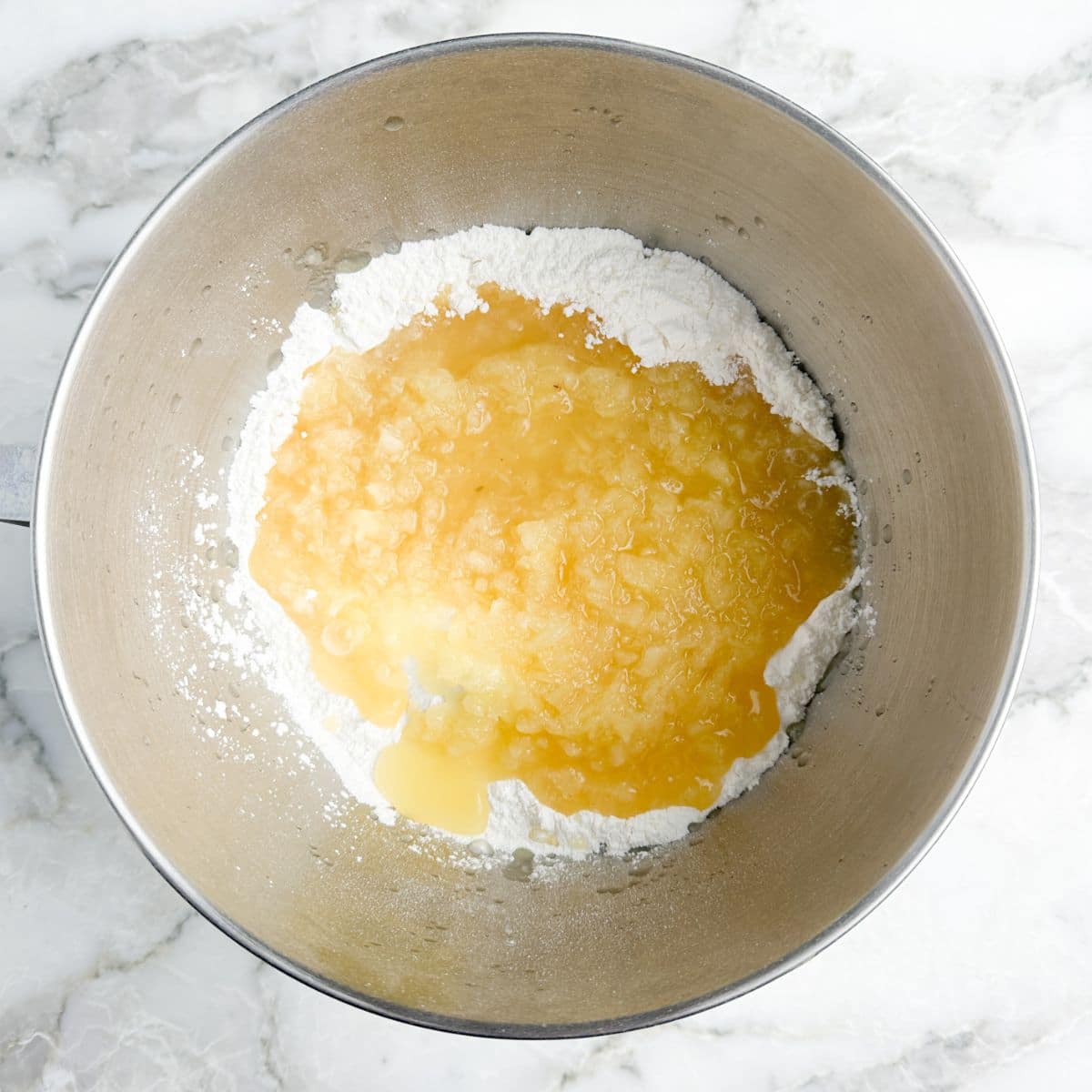 Mixing bowl with angel food cake mix and crushed pineapple.