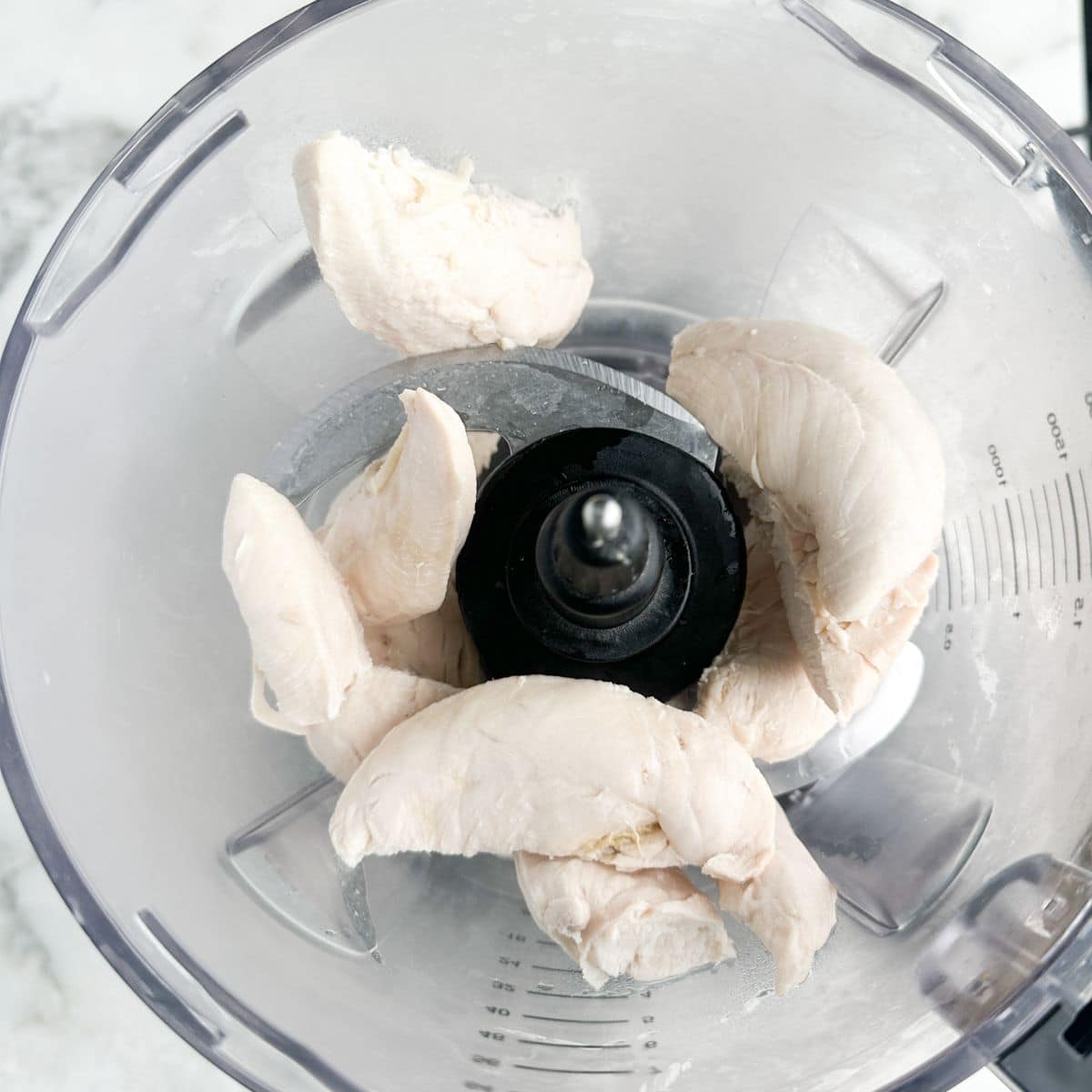 Food processor with chicken tenderloins.