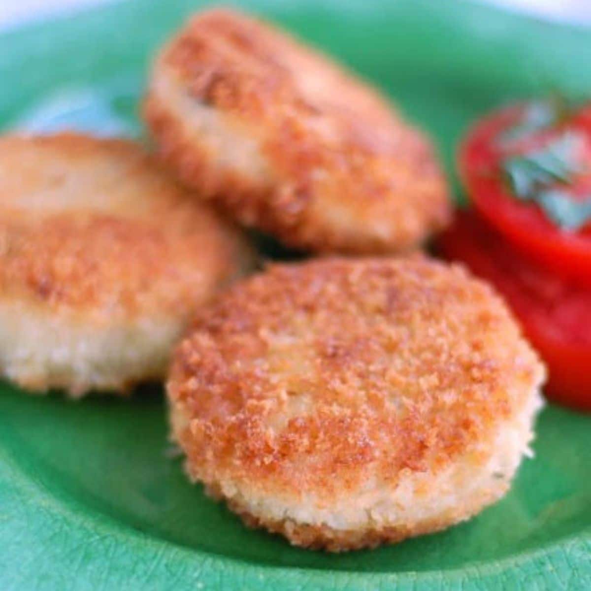 Green plate with chicken croquettes.