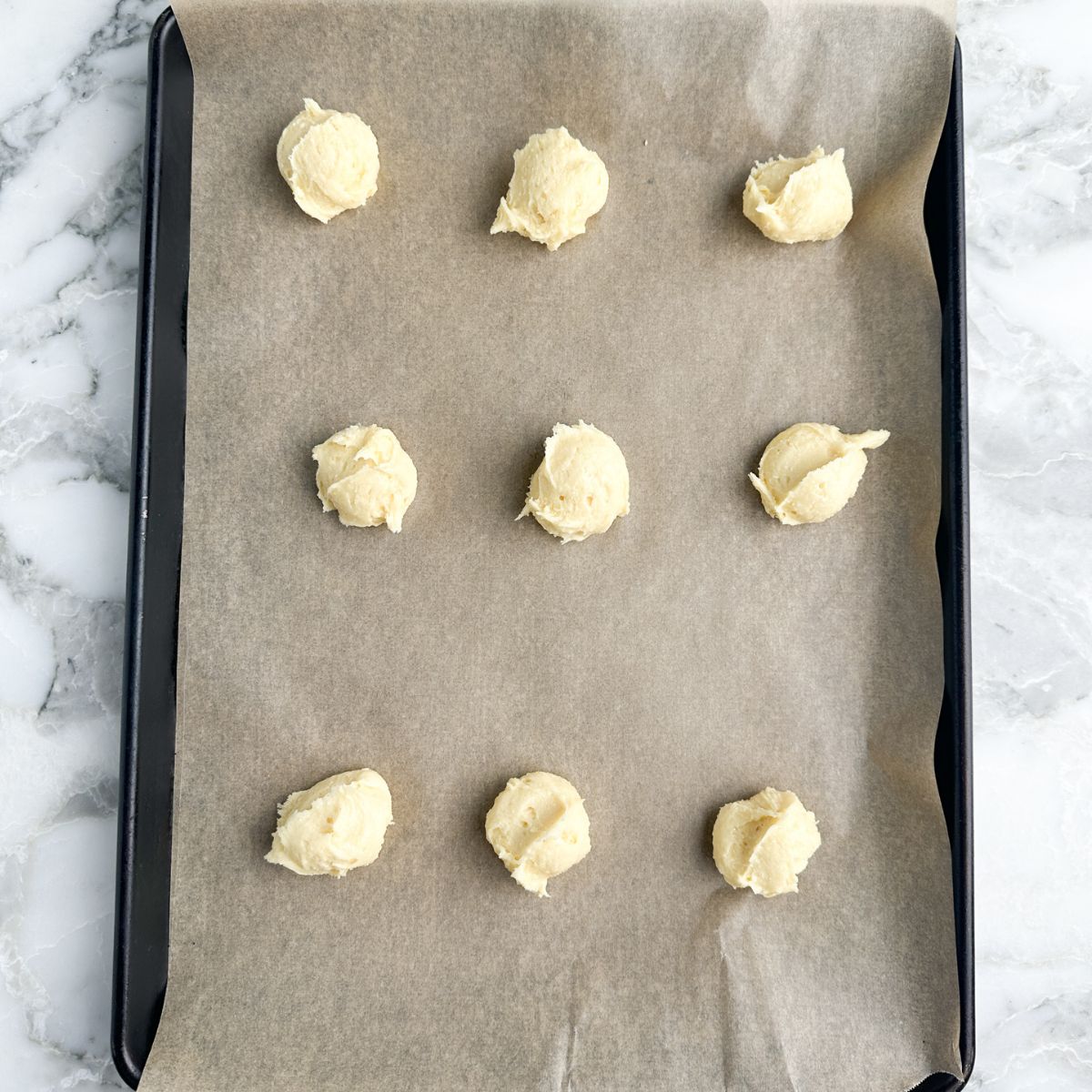 Cookie dough scooped on baking sheet. 