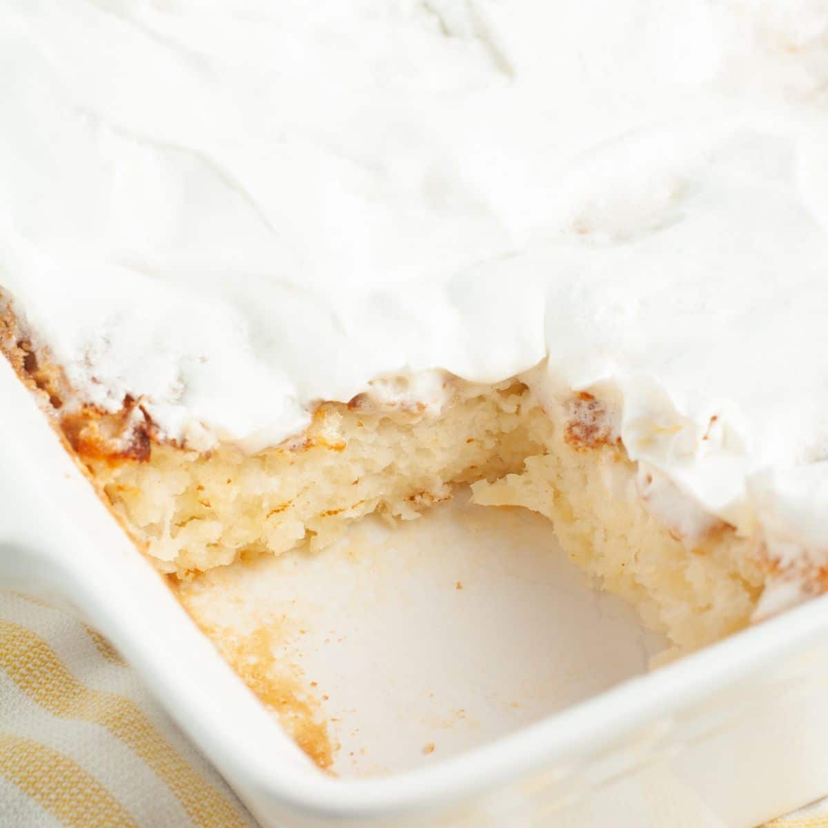 Baking dish with angel food cake topped with Cool Whip.