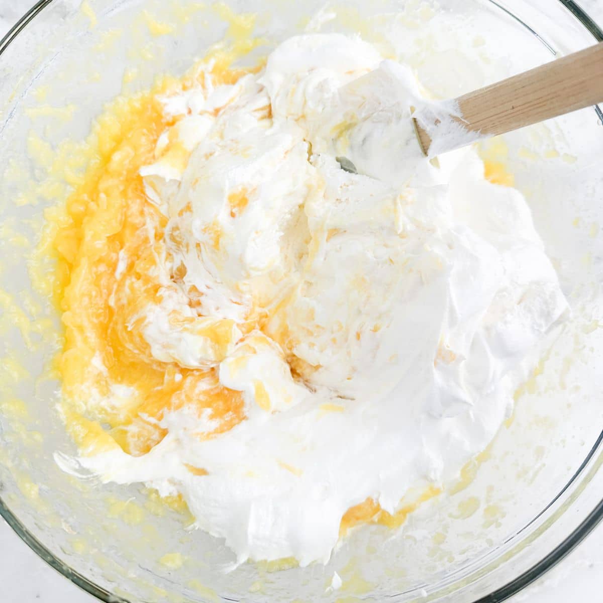 Bowl of Cool Whip and crushed pineapple.