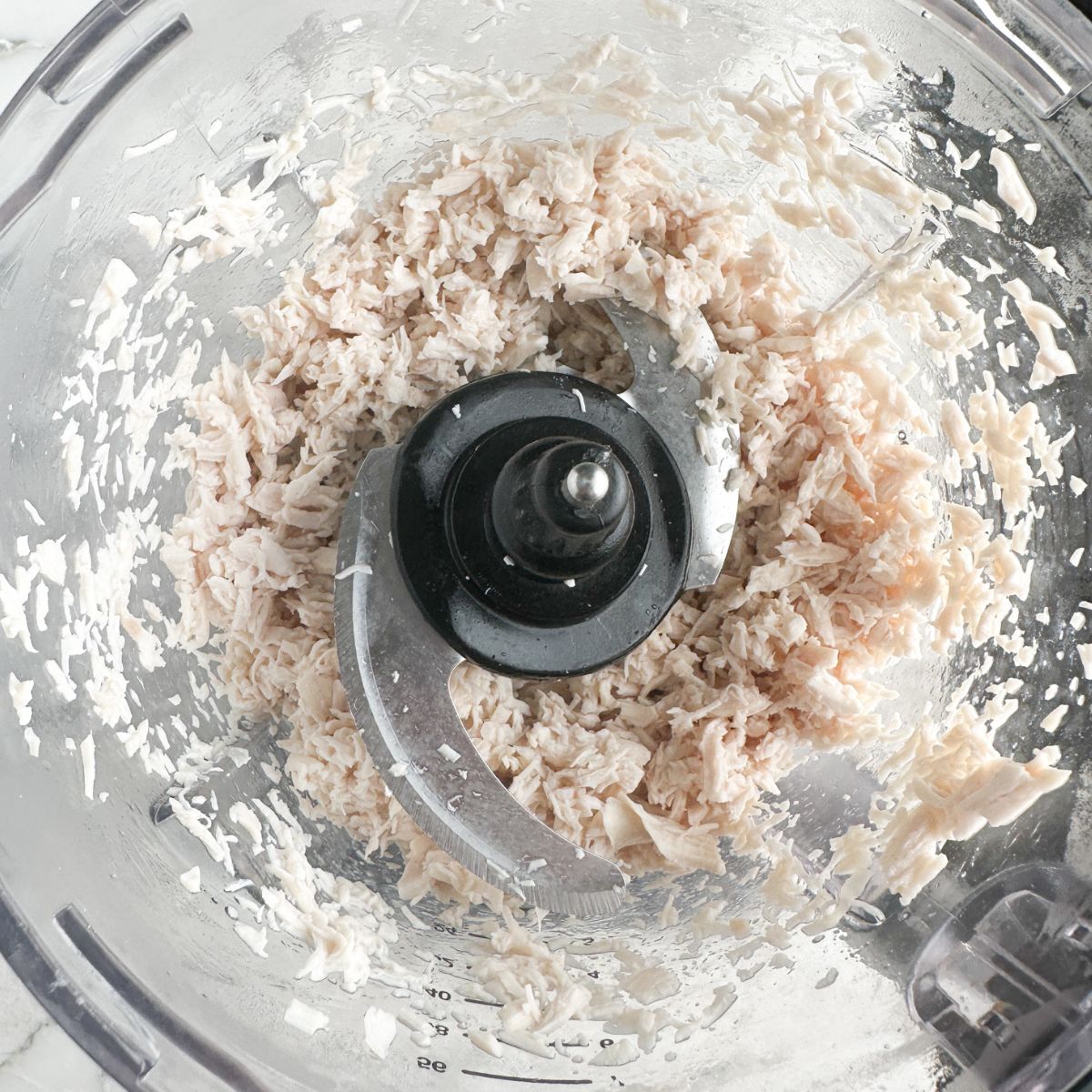 Shredded chicken in food processor.