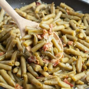 Skillet with green beans and bacon bits.