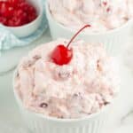 Bowl of cherry fluff topped with a cherry.
