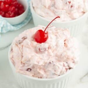 Bowl of cherry fluff topped with a cherry.