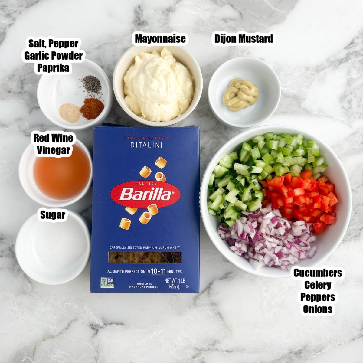 Box of pasta, bowl of sugar, vinegar, seasonings, mayonnaise, mustard, and vegetables.