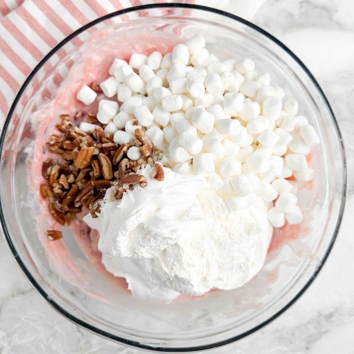 Bowl with mini marshmallows, chopped pecans, and Cool Whip.