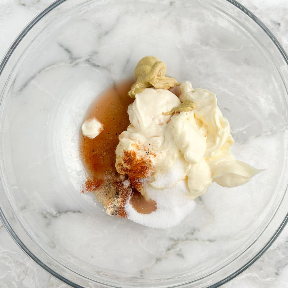 Bowl with mayonnaise, mustard, vinegar, and seasonings. 