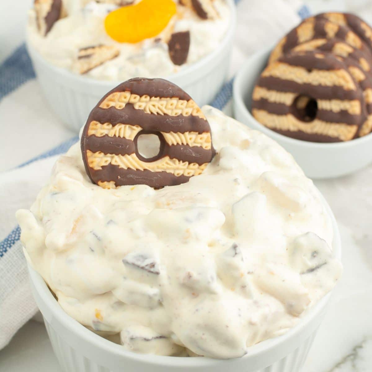 Bowl with creamy dessert salad and topped with a fudge stripe cookie.