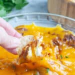 Chip scooping chili cheese dip.