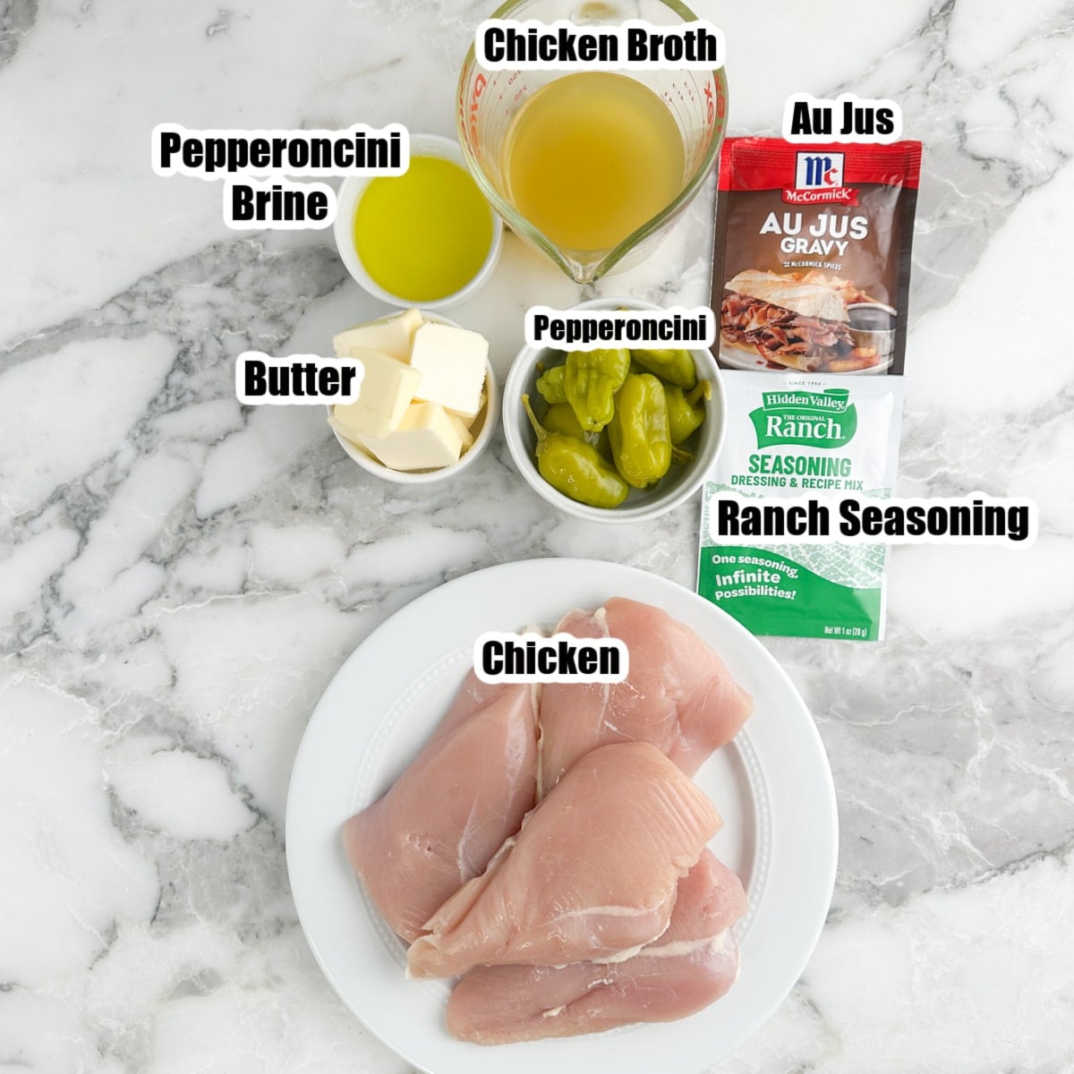 Plate of chicken breasts, broth, au jus packet, ranch seasonings, butter, and pepperoncinis.