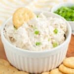 Bowl of crab dip with a Ritz cracker in the dip.
