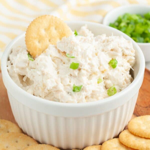 Bowl of crab dip with a Ritz cracker in the dip.