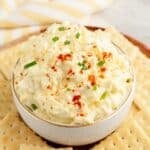 Bowl of deviled egg dip surrounded by crackers.