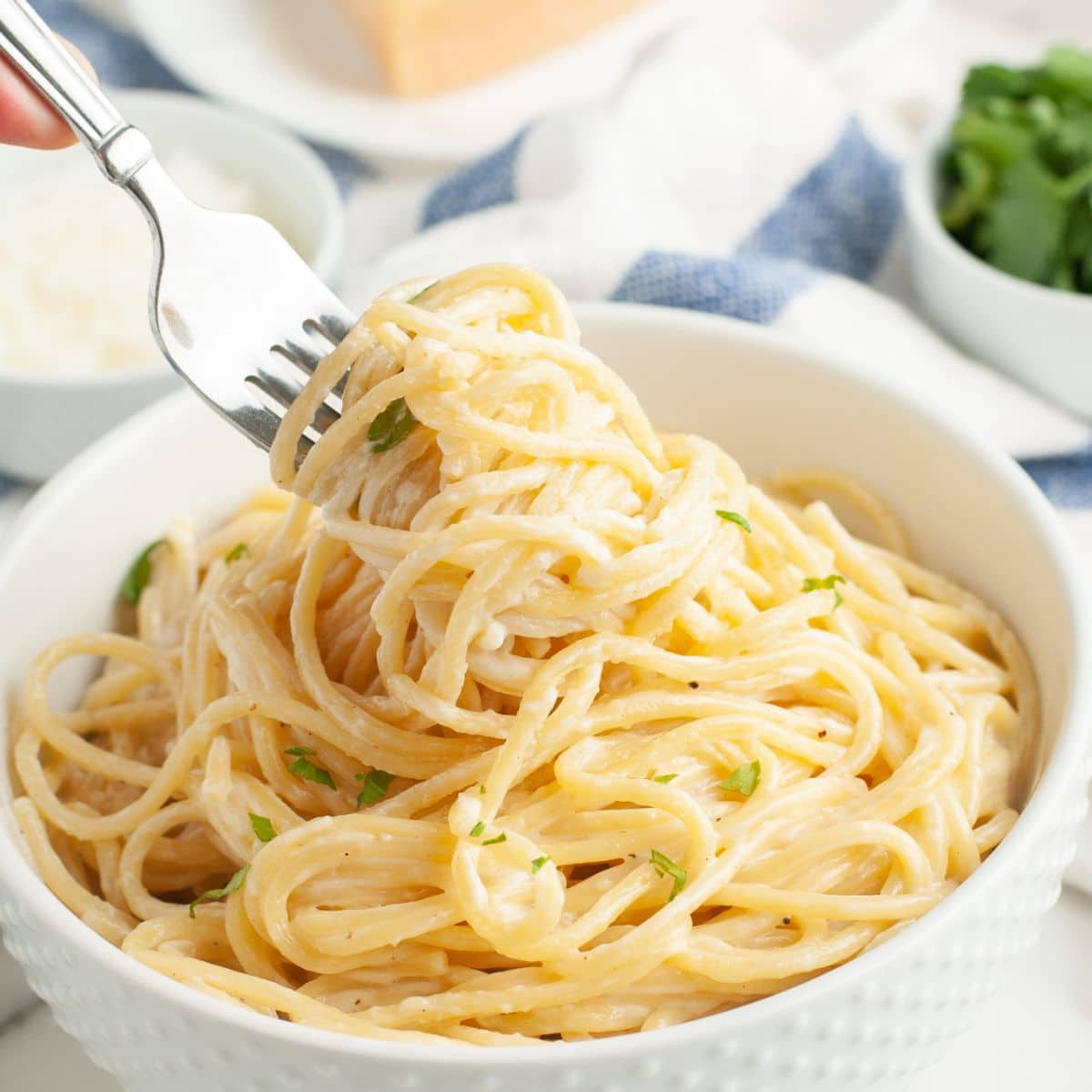 Bowl of spaghetti alfredo with a fork.