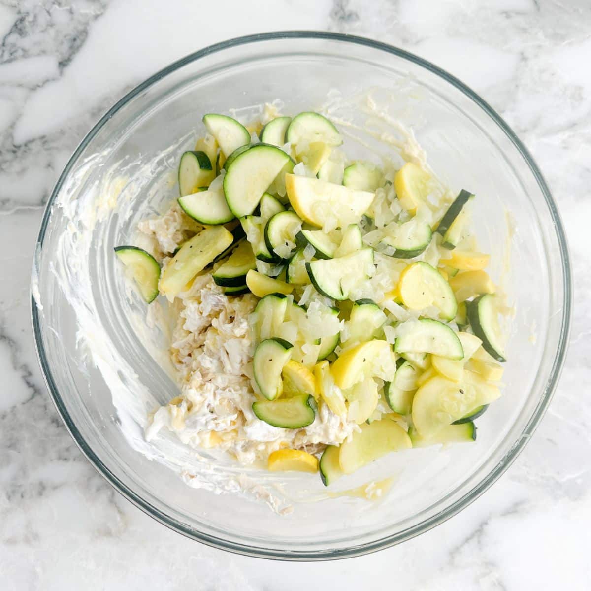 Bowl with zucchini, yellow squash, chicken, and cheese.