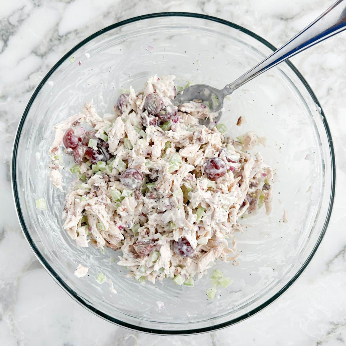 Bowl of chicken salad with a spoon.