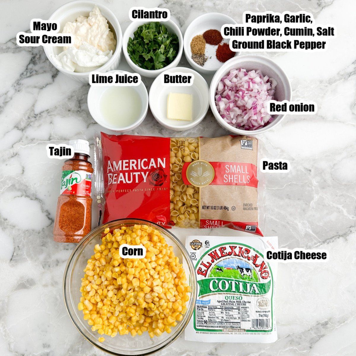 Pasta, bowl of corn, cotija cheese, onions, Tajin, mayo, seasonings, and cilantro.