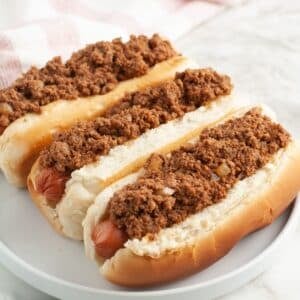 Plate of three chili dogs.