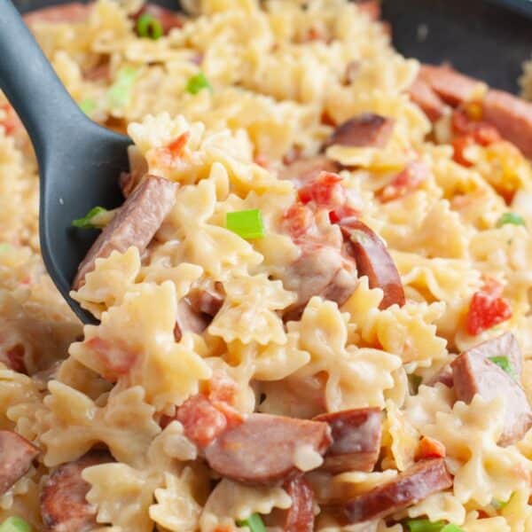 Spoon scooping kielbasa pasta.