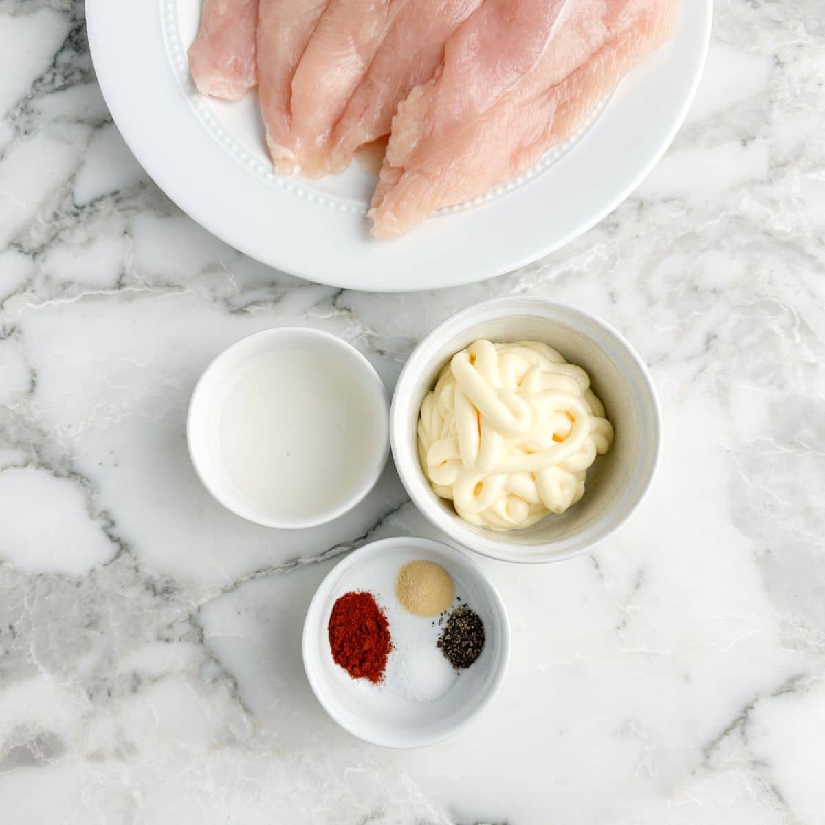 Chicken breasts, bowl of pickle juice, mayonnaise, and seasonings.