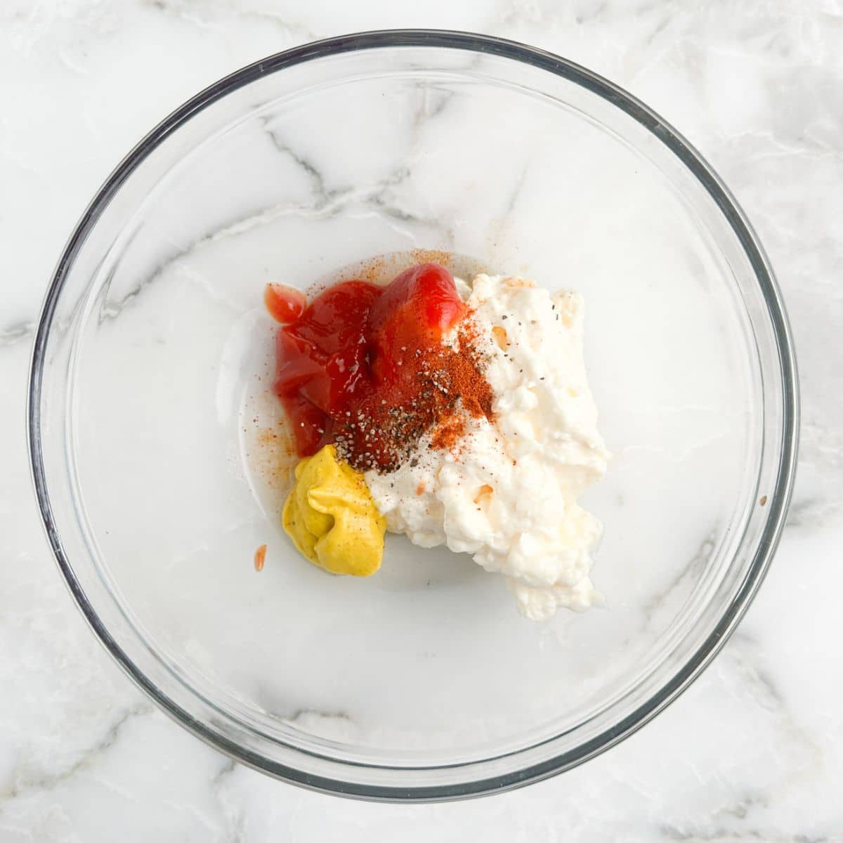 Bowl with ketchup, mustard, mayonnaise, and seasonings.