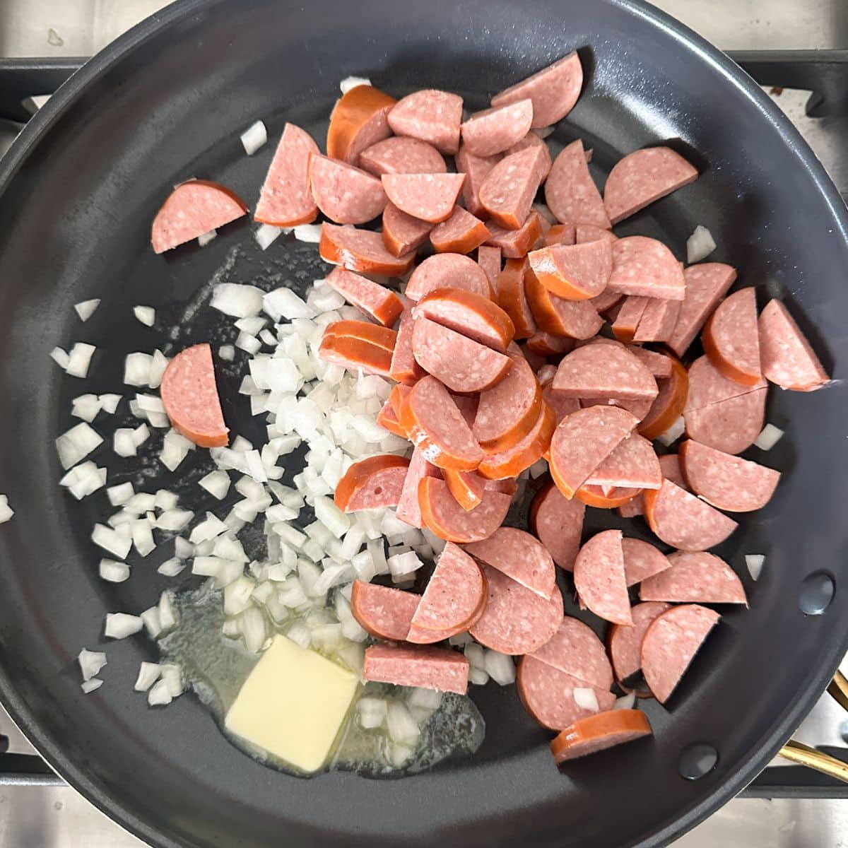 Skillet with kielbasa, onions, and butter.