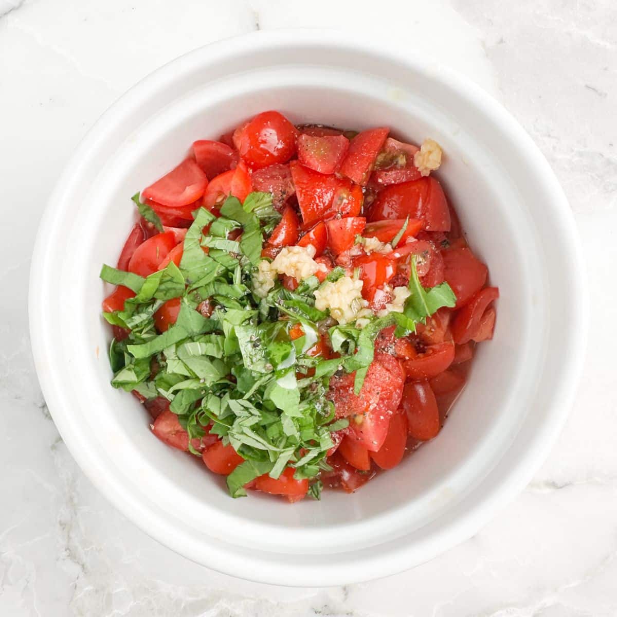 Bowl with diced tomatoes and fresh basil.