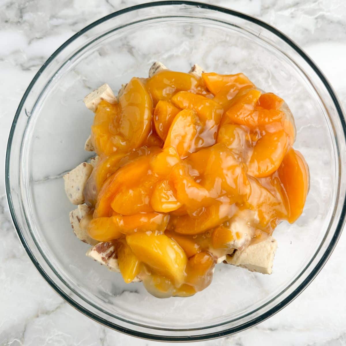 Bowl of cinnamon rolls with peach pie filling.
